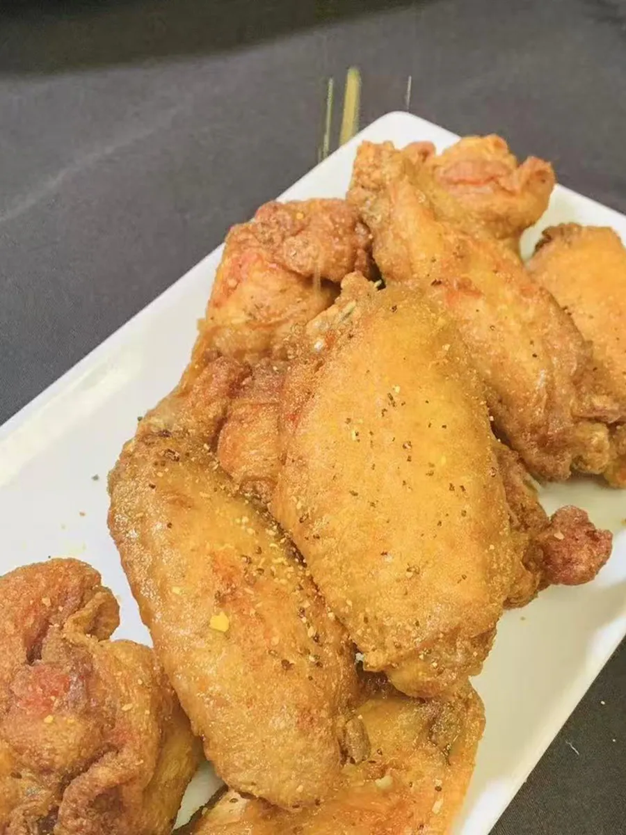 Crispy seasoned fried chicken wings on white plate at Kungfu Rice, a Chinese Fast Food Restaurant in Savannah