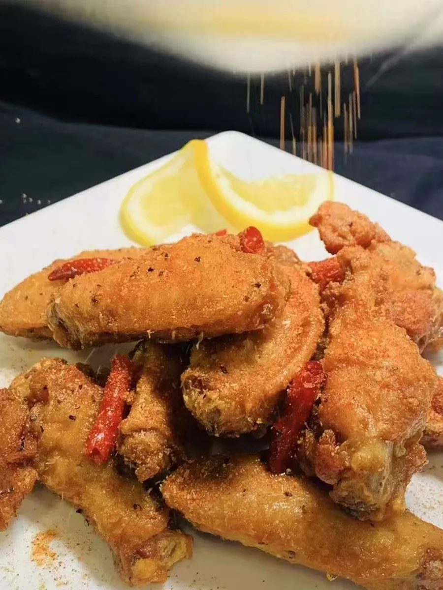Spicy seasoned fried chicken wings with lemon wedge at Kungfu Rice, a Chinese Fast Food Restaurant in Savannah
